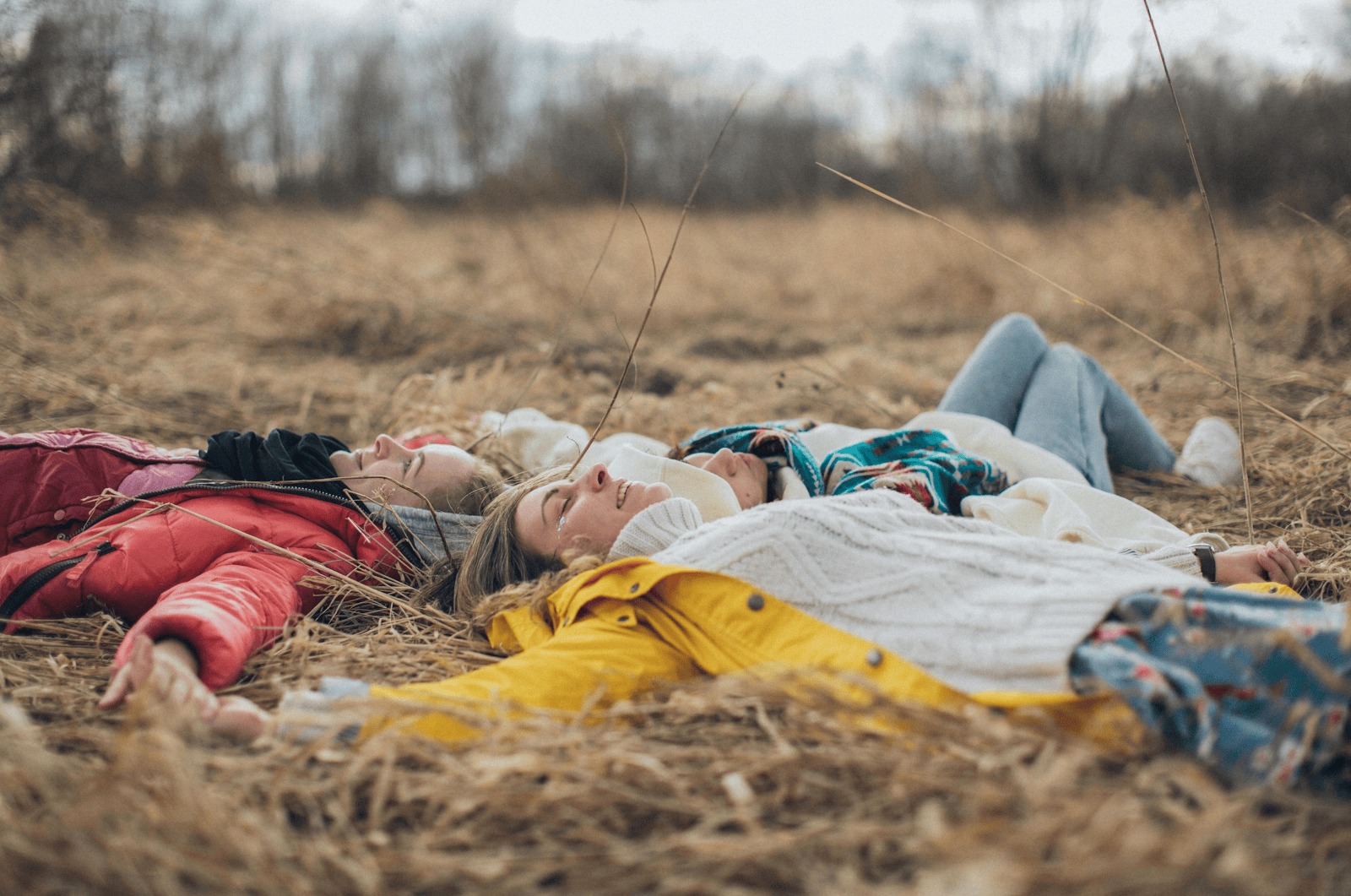 three people laying on the field